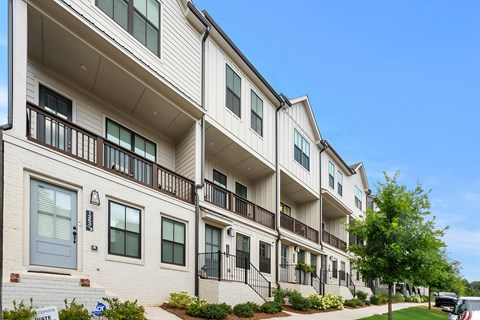 A row of townhouses with a clear blue sky above.