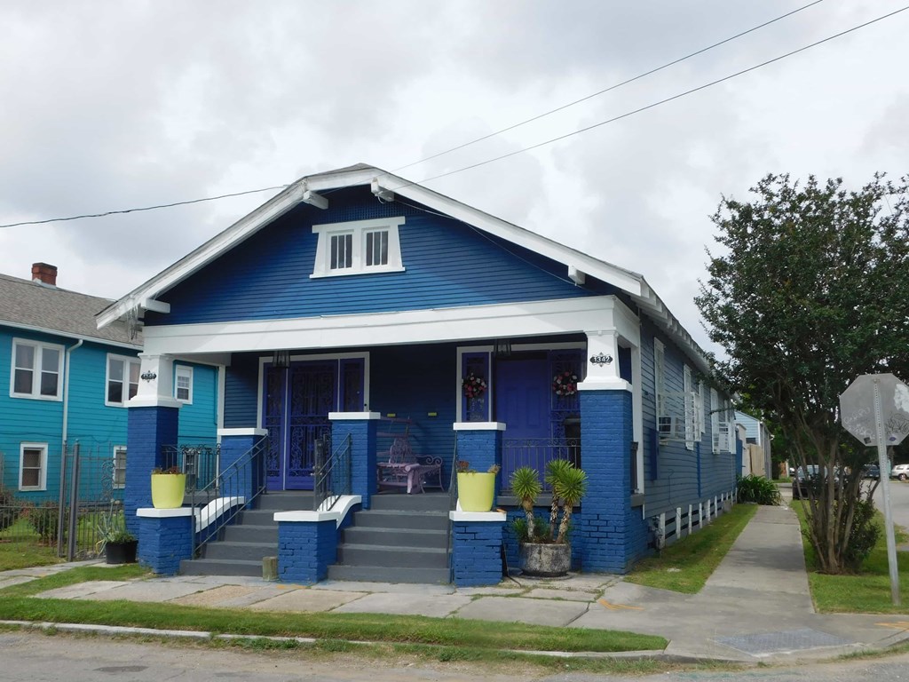 A blue house with a white door and windows.