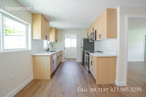 A kitchen with wooden cabinets and a refrigerator with a microwave above it.