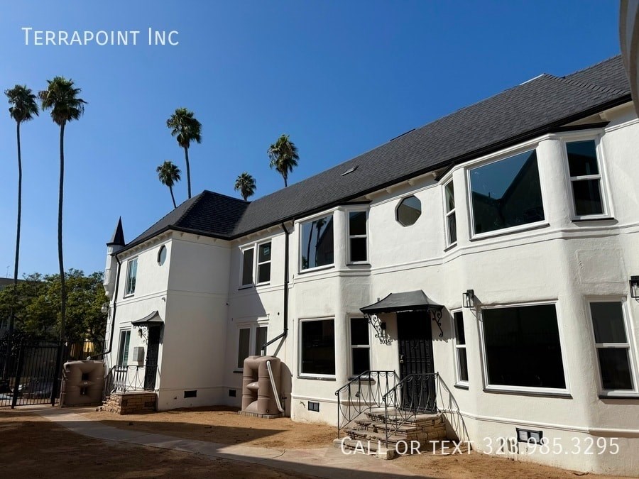 A white two-story building with a black roof and a sign that says "Terrapoint Inc."
