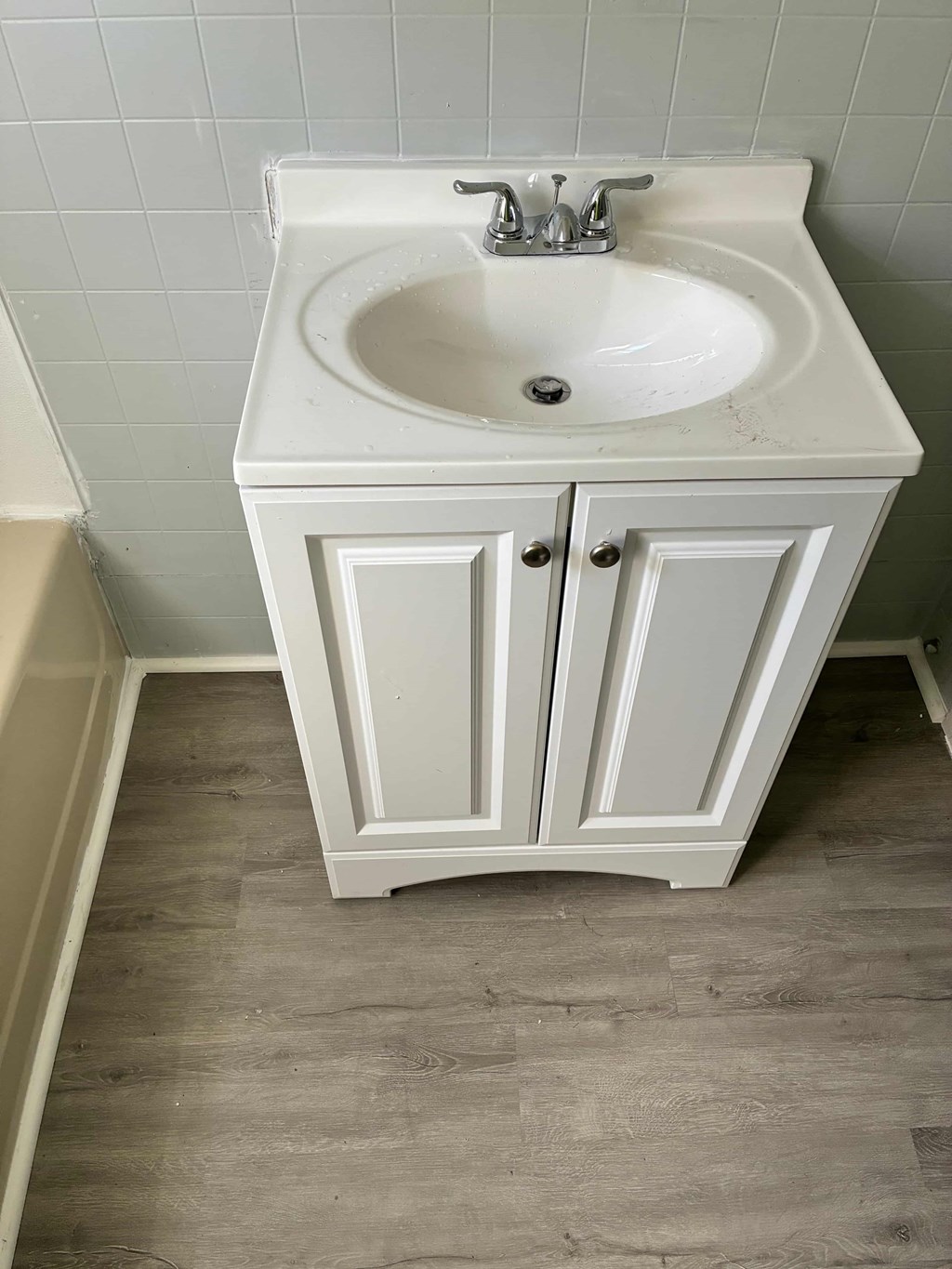 A white sink with a cabinet below it.