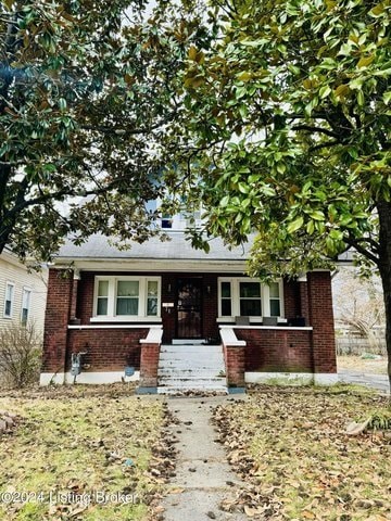 A small house with a brick facade and a porch.