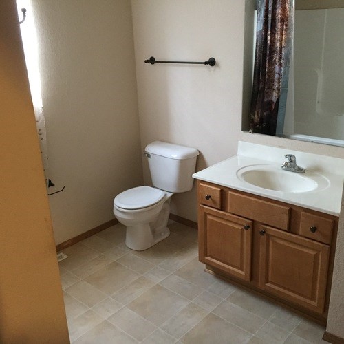 A white toilet sits next to a sink in a bathroom.