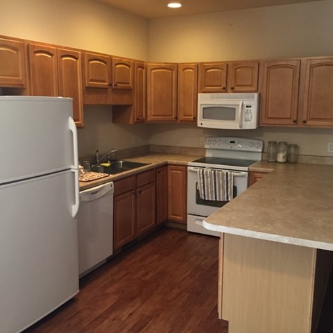 A kitchen with wooden cabinets and a white refrigerator.