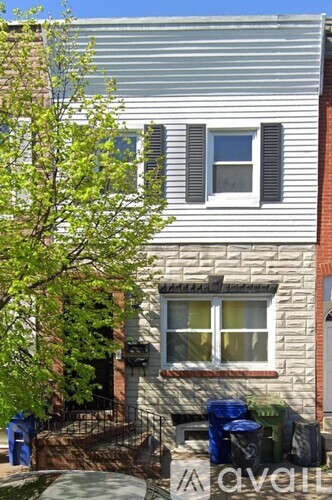 A house with a window and a tree in front of it.
