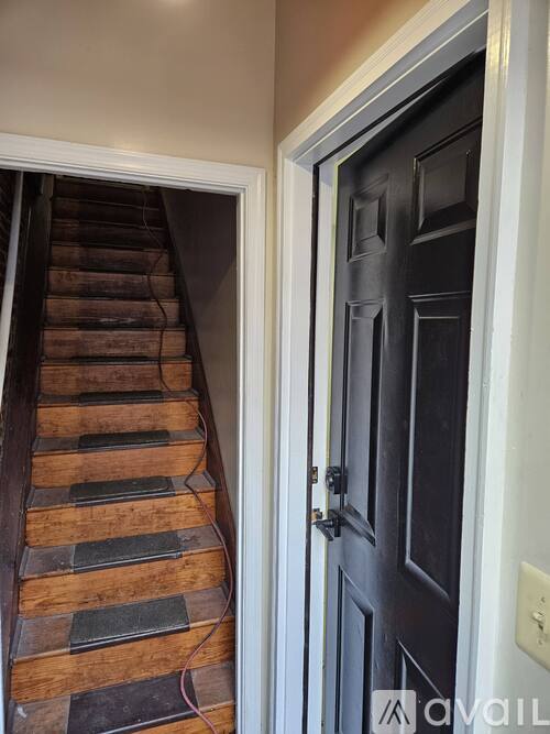 A set of stairs leading up to a black door.