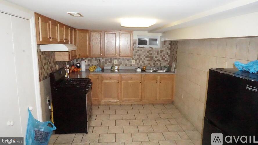 A kitchen with brown cabinets and black appliances.
