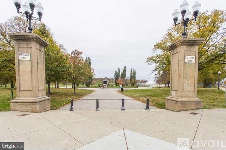 A park with a walkway and two pillars on either side.