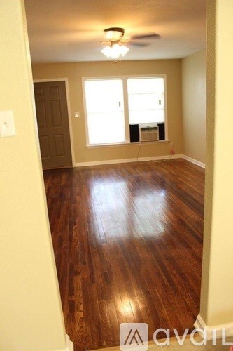 A room with wooden floors and a ceiling fan.