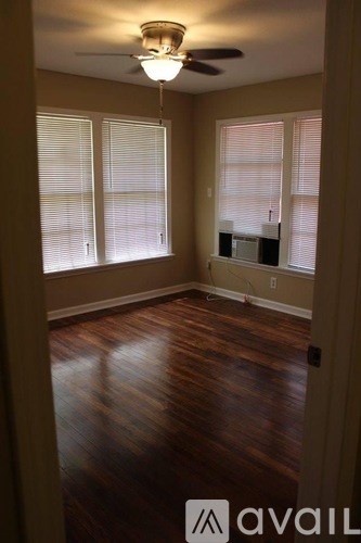 A room with wooden floors and a ceiling fan.