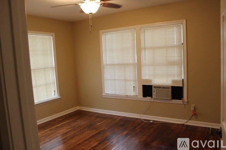 A room with wooden floors and a ceiling fan.