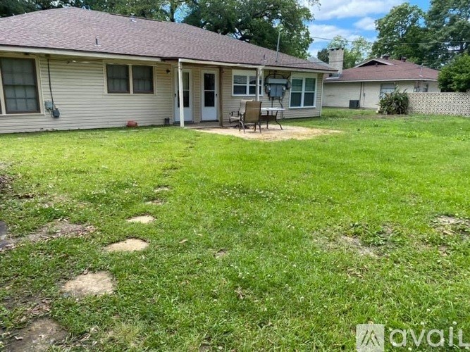 A house with a lawn and a patio table.
