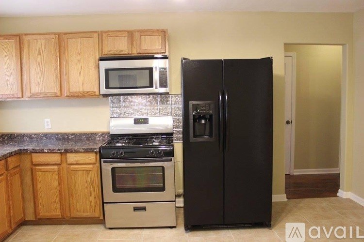 A kitchen with a black refrigerator, stove, and oven.