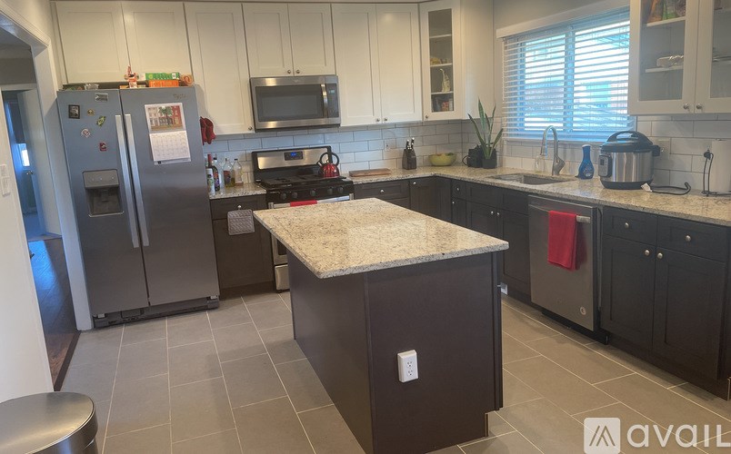 A kitchen with a refrigerator, microwave, and oven.