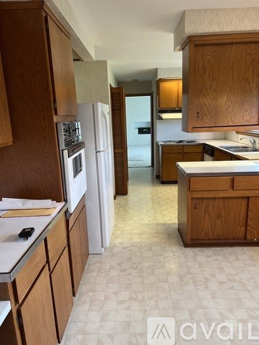 A kitchen with wooden cabinets and a white refrigerator.