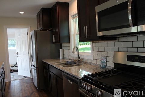A kitchen with a black stove top oven and a black microwave above it.