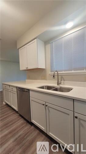 A kitchen with white cabinets and a sink.