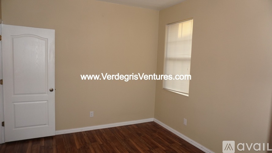 A room with a white door and a window with blinds.