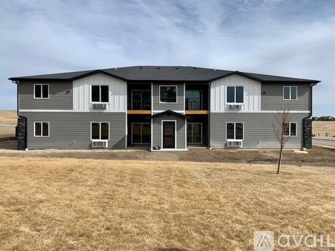 A modern two-story house with a large front yard.