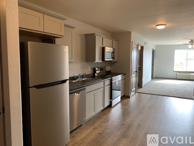A kitchen with a refrigerator, microwave, and oven.