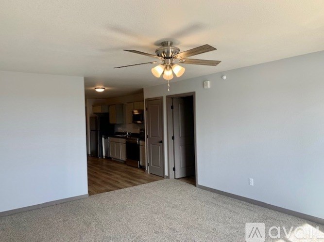A room with a ceiling fan and carpeted floor.