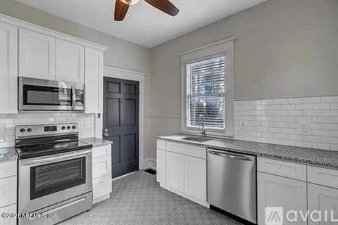 A kitchen with white cabinets and a stainless steel dishwasher.