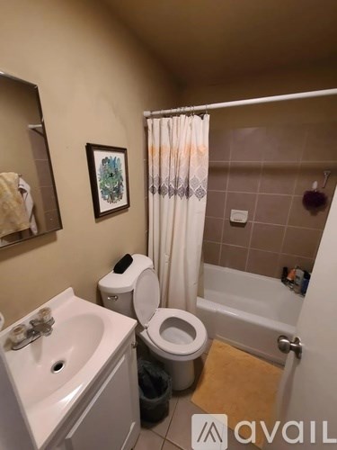 A bathroom with a toilet, sink, and shower.