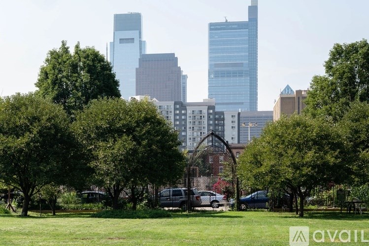 A park with trees and a city skyline in the background.