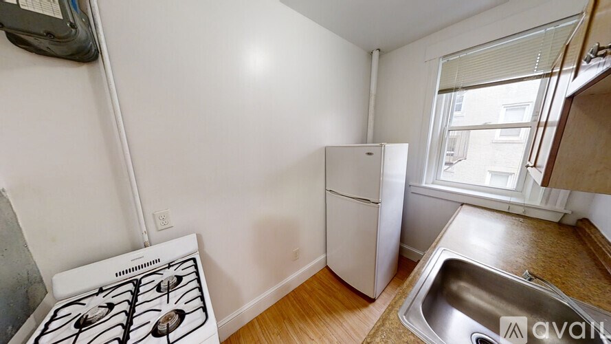 A kitchen with a stove, refrigerator, and sink.