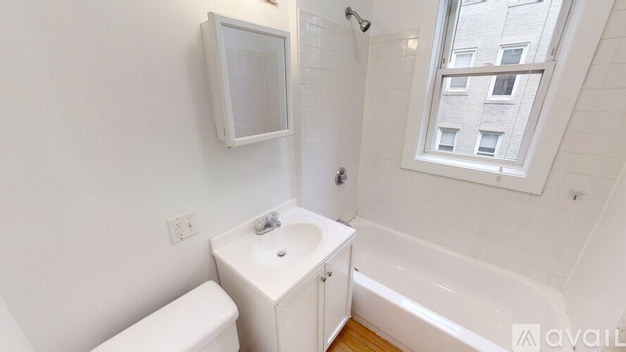 A white bathroom with a toilet, sink, and bathtub.