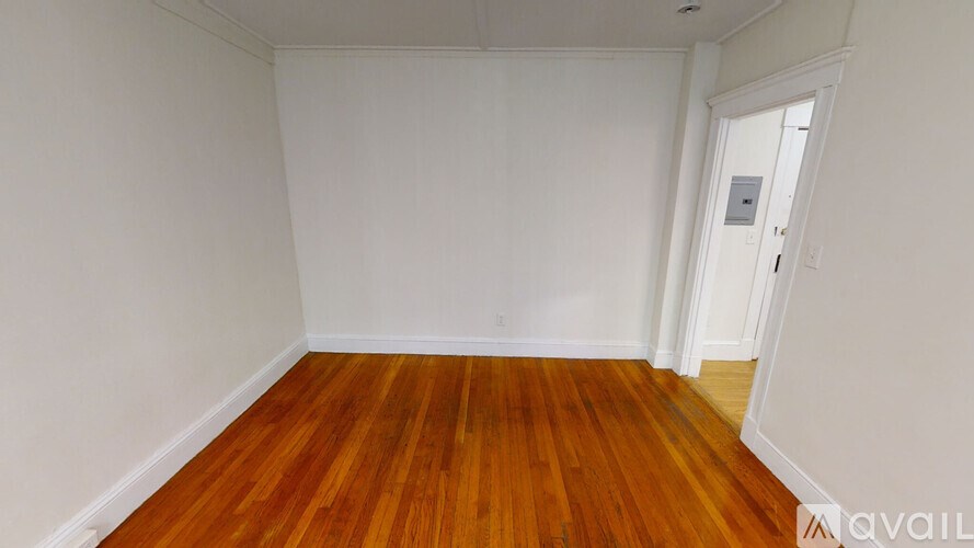 A room with wooden flooring and white walls.