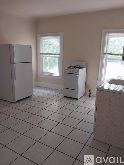 A kitchen with a white fridge, white stove, and white oven.