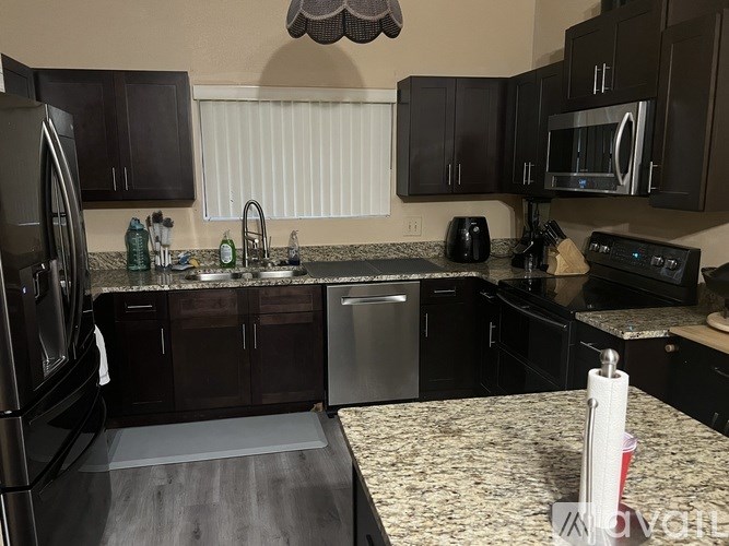 A kitchen with black cabinets and granite countertops.