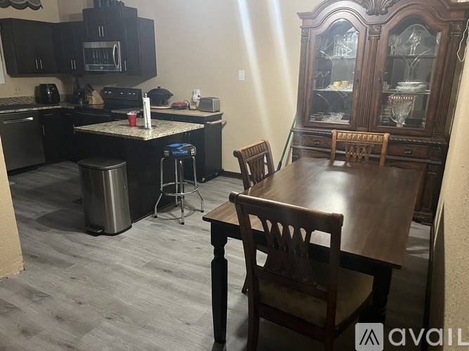 A kitchen with a table and chairs in front of a cabinet.
