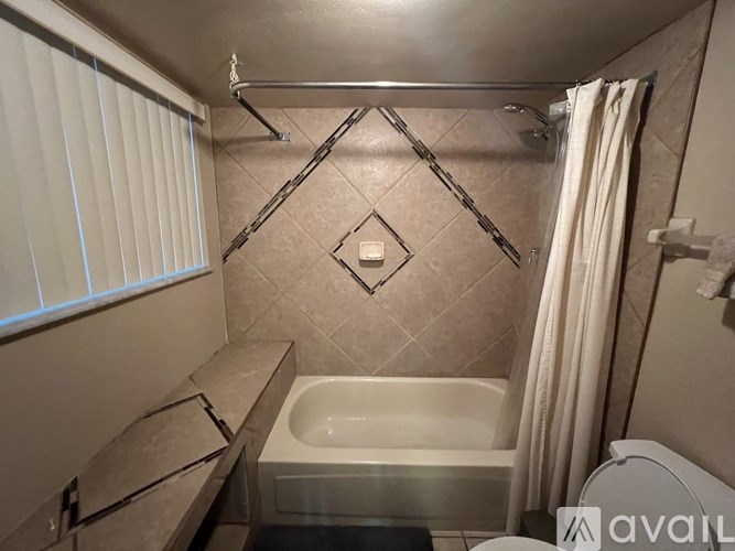 A bathroom with a tub, toilet, and sink.