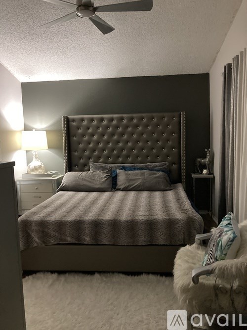 A bedroom with a large bed and a ceiling fan.