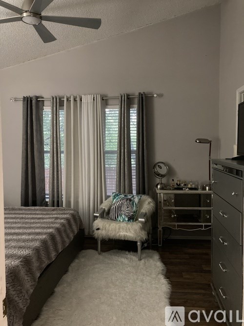 A bedroom with a bed, chair, and dresser.