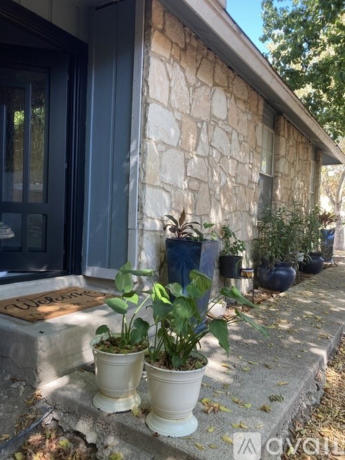 A house with a stone wall and a brown door.