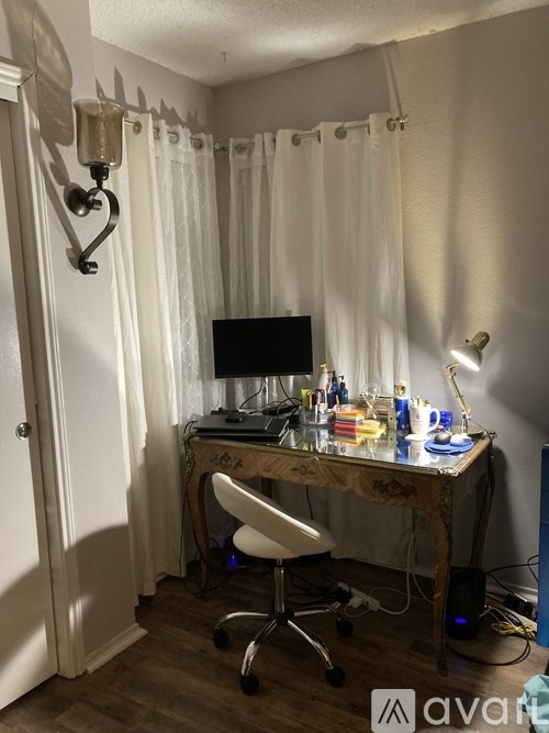 A room with a desk, chair, and computer.