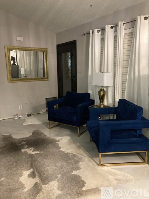 Two blue chairs with gold legs in a room.