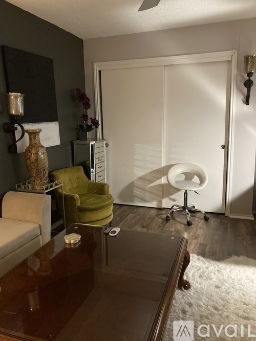 A living room with a brown table and a green chair.