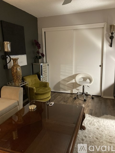 A living room with a brown table and a green chair.