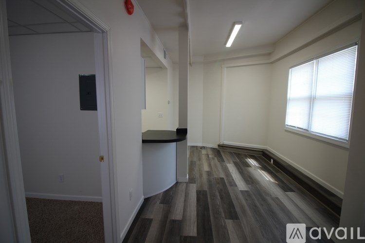 A room with a window and a wooden floor.