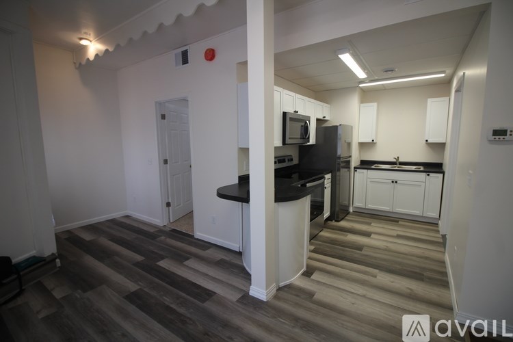 A kitchen with a black countertop and white cabinets.