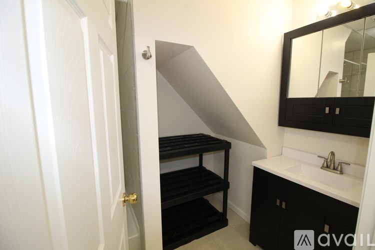 A bathroom with a sink, mirror, and shelves.