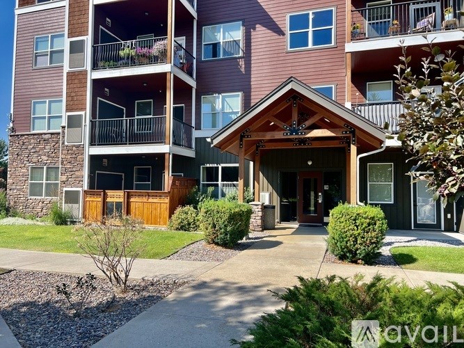 A building with a brown roof and a stone pillar in front.