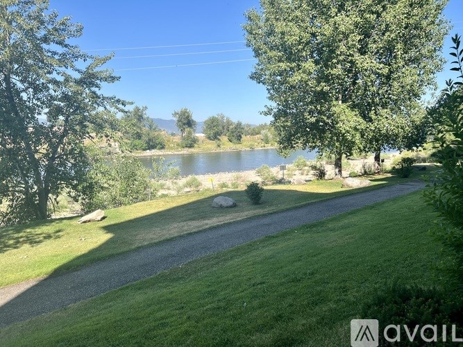 A pathway leads through a grassy area to a body of water.