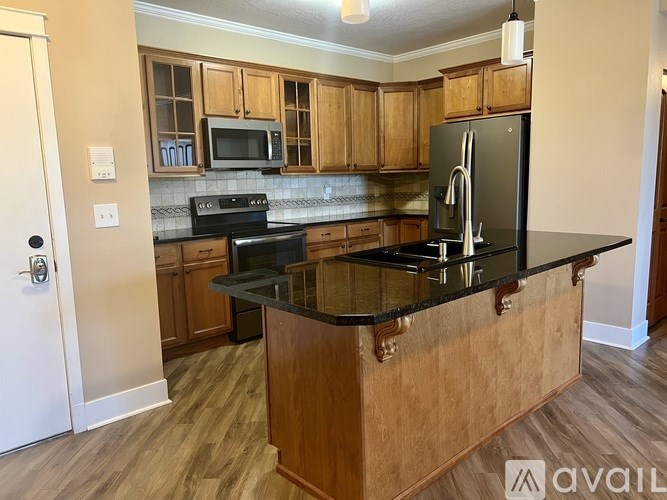 A kitchen with wooden cabinets and black countertops.