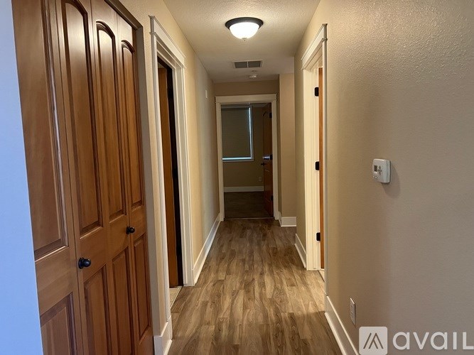 A hallway with wooden doors and a light on the ceiling.