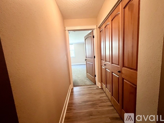 A hallway with wooden doors and a carpeted floor.